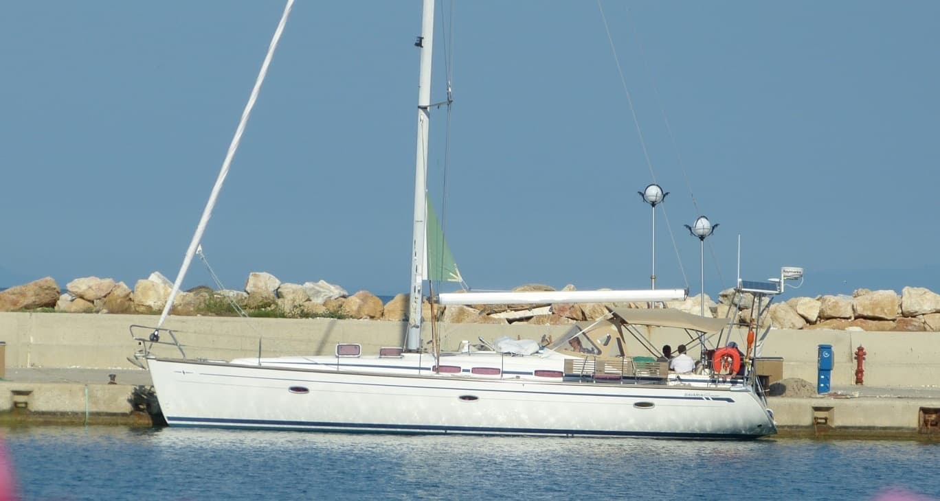 The yacht seen from the side, moored in a marina