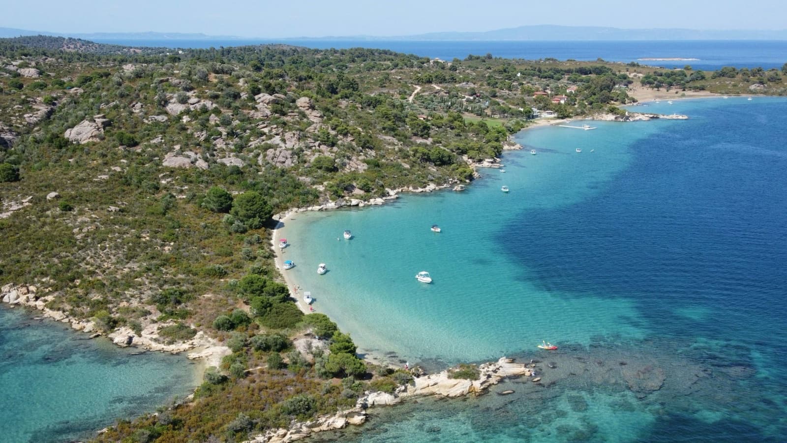 Aerial view of a turquoise bay on Halkidiki with boats at anchor
