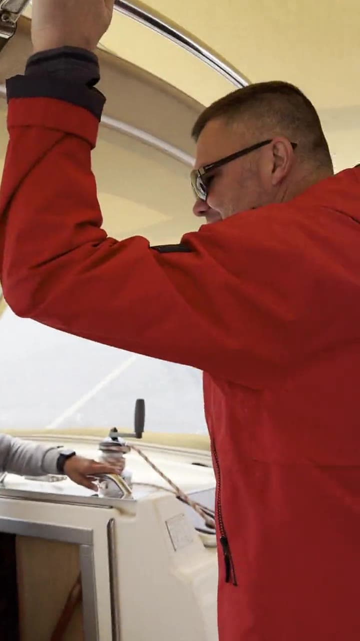 The skipper at the helm while the yacht heels in the wind