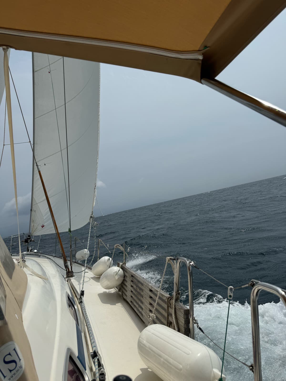 The yacht heeling with the sails full and the sea rushing past